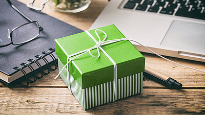 Geschenk mit Schleife in grünem Karton